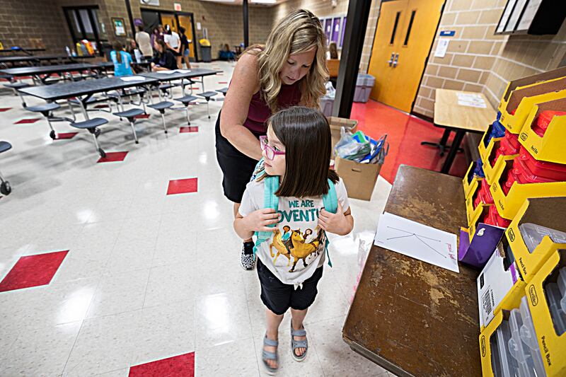 Dixon Tools for School coordinator Mandy Dallas helps Lucy Smits, 6, with some new supplies Thursday, August 10, 2023 at Reagan Middle School.
