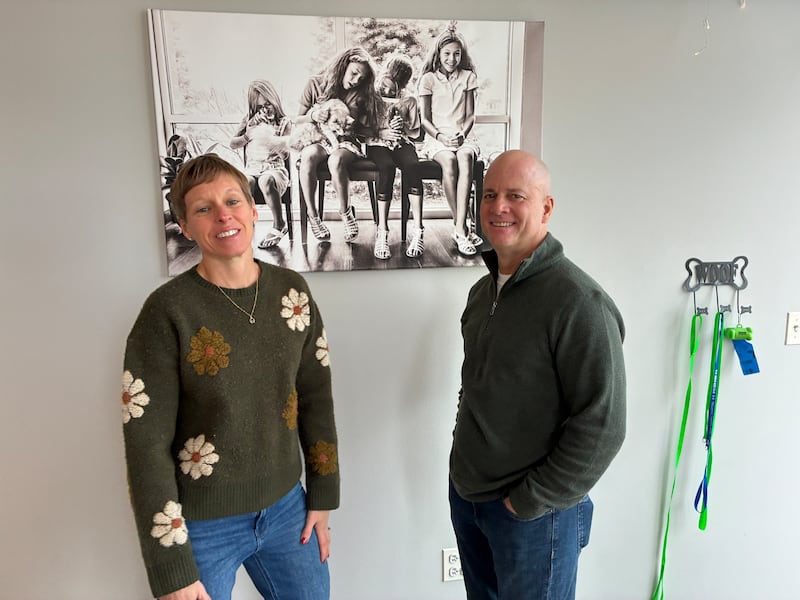 Karen and John Ferrero, seen here with a photo of their four daughters on Friday, Feb. 6., 2026, at Healthy Paws Animal Hospital in Lake in the Hills. The couple has given nearly $30,000 to CASA McHenry County's Family Support Fund, providing opportunity scholarships to nearly 200 children in foster care.