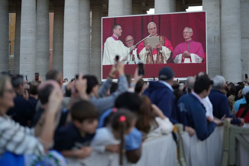 Faithful listen the speech of the newly elected Pope Leo XIV at the Vatican, Thursday, May 8, 2025. (AP Photo/Francisco Seco)