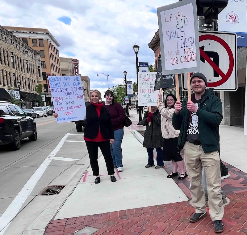 Attorney Roger Erickson (right) holding a sign with other legal aid union members on Friday, May 1, 2026, in downtown Joliet.