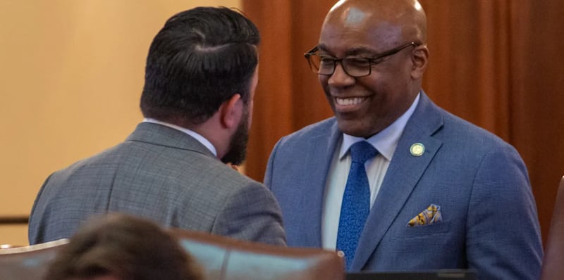 Illinois Attorney General Kwame Raoul speaks to state Sen. Omar Aquino, D-Chicago, on the floor of the Illinois Senate on May 30, 2025.