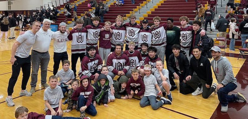 The Wheaton Academy boys wrestling team and young fans pose after winning the Class 1A Richmond-Burton Regional on Saturday, Jan. 31, 2026.