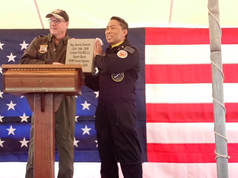 Guest speaker Major Dennis Davoren, a retired Air Force pilot, is presented with a commemorative brick by JoJo Sayson, coordinator of the Ray Olley Memorial Project. Davoren was the keynote speaker Saturday at the Veterans’ Day services at the statue. The event is meant to call attention to the problem of PTSD.