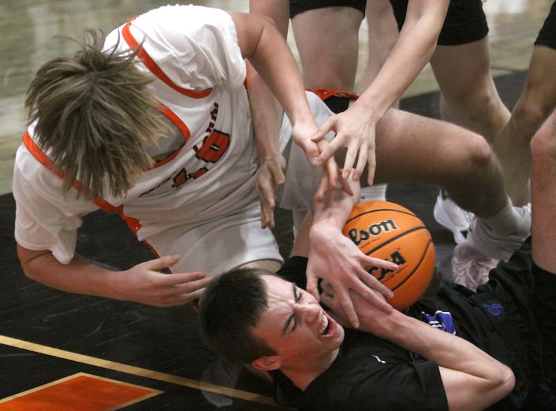 McHenry’s Nathan Ottaway, left, tussles with Burlington Central’s Patrick Magan, bottom, for the ball in varsity boys basketball on Friday, Dec. 5, 2025, at McHenry Community High School in McHenry.