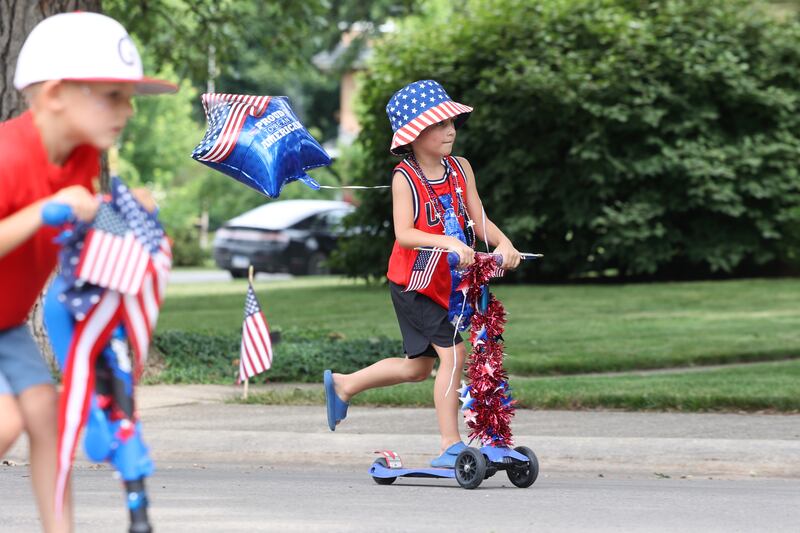 Max Cooke, 5, of Kankakee, rides his decorated scooter in the Kids' Bike Ride during the Riverview Historic District's annual 4th of July Celebration on Friday, July 4, 2025. Cooke was named Mister Firecracker for the day's festivities.