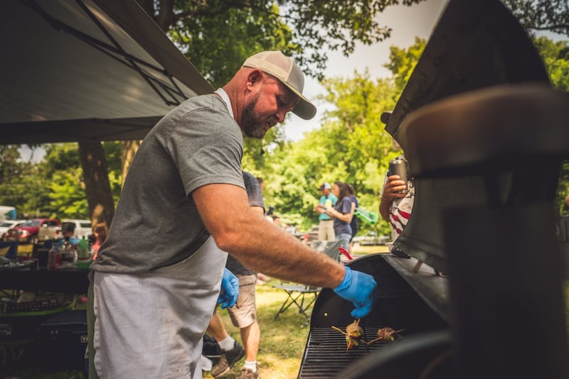 A contestant in the Rhythm & BBQ Festival works at the grill.