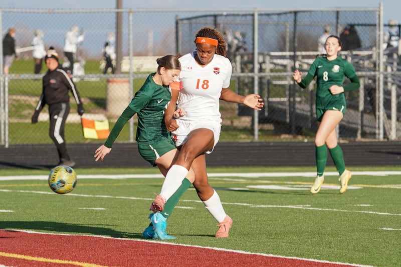 Oswego’s Jordyn Washington (18) takes a shot for a goal against Bartlett’s Alayna Ernst during a soccer mach in the Plainfield Classic  at Plainfield North High School on Tuesday, April 15, 2025.