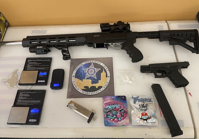 The Aurora Police Department released a photo of an assault-style weapon and drug paraphernalia collected during a warrant on a residence in Aurora.