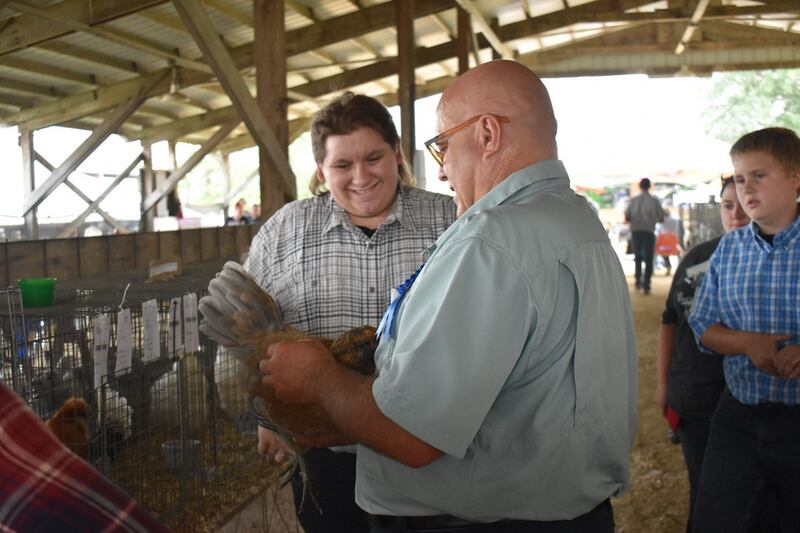 Kaden Lingbeck conferences with the judge during the 4-H Poultry Show.