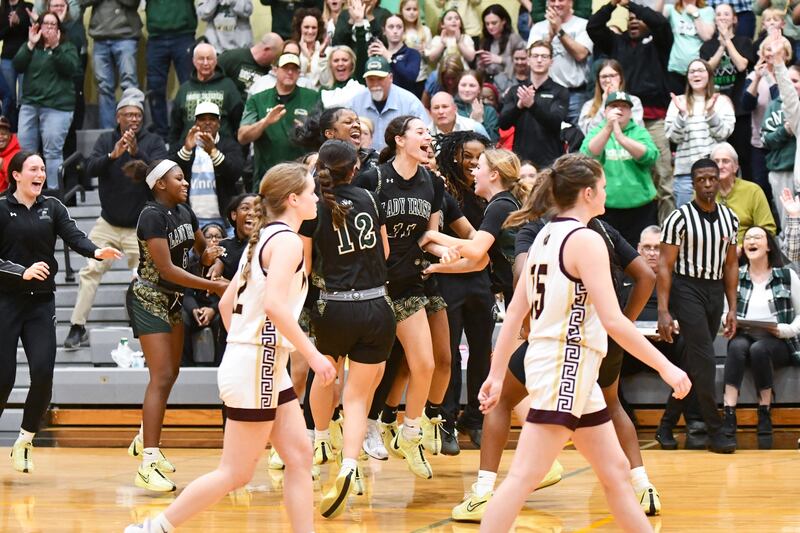 Bishop McNamara players surround teammate Trinity Davis, center, to celebrate as the Fightin' Irish secured a 69-38 victory over Watseka-Milford in the IHSA Class 2A Herscher Sectional championship on Thursday, Feb. 27.