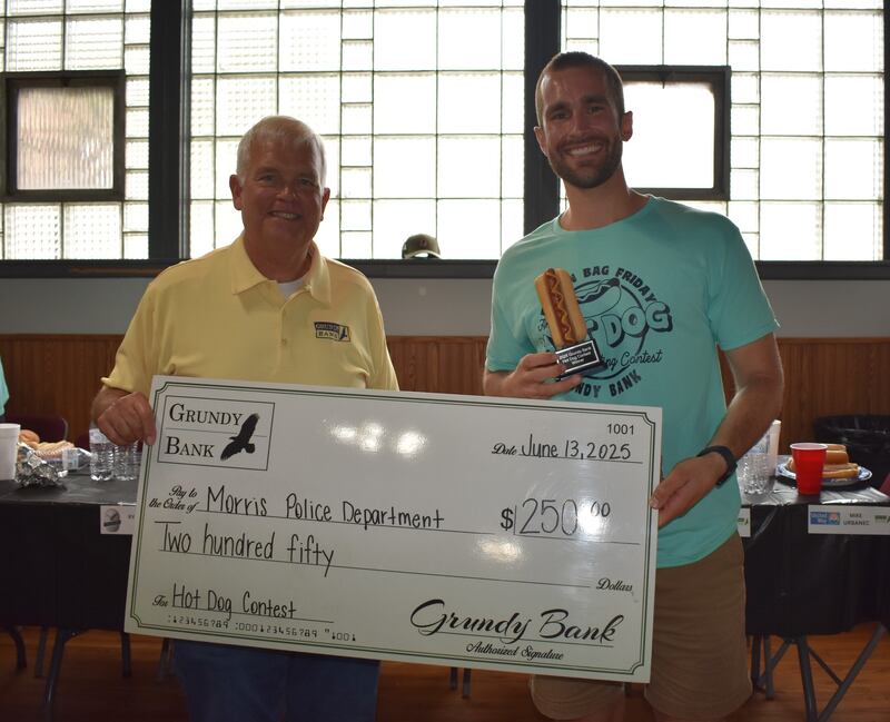 Grundy Bank CEO Kevin Olson (left) and Officer Ryan "The Gobbler" Ties, winner of the 2025 Grundy Bank hot dog eating contest.