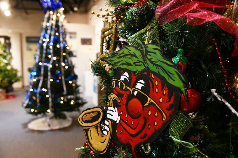 A tree decorated by the Community Arts Council of Kankakee County features the Strawberry Jazz Festival logo ahead of the 46th Annual Gallery of Trees at the Kankakee County Museum. The gallery features over thirty-five trees decorated by area non-profit organizations this year.