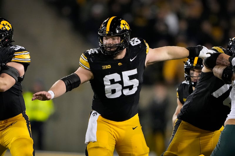 Iowa offensive lineman Logan Jones (65) looks to make a block during the second half of an NCAA college football game against Michigan State, Saturday, Nov. 22, 2025, in Iowa City, Iowa. (AP Photo/Charlie Neibergall)