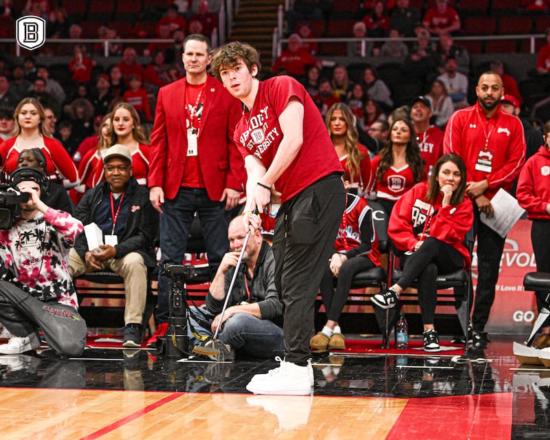 Trevor Frey, a Bradley University freshman from Lake in the Hills, putts across the basketball court on March 2, 2025, in a contest for a new car, which he won by making the shot.