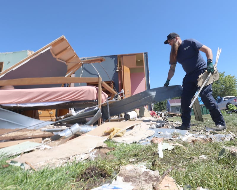 Jake Cook of Inverengy volunteers his time by removing sheet metal from a damaged home from the tornado on Sunbury Drive on Monday, June 15, 2026 in Streator.