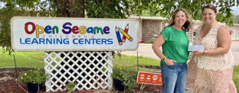 Anne-Marie Williams of Prairie Brome Solar (left) presents a grant check to Cassie Halvorson, executive director of Open Sesame in Dixon.