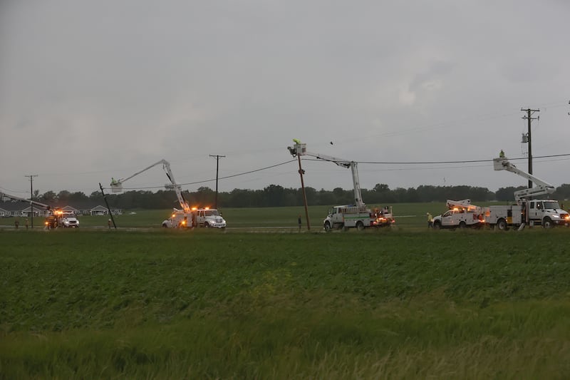 Multiple electric trucks restore power lines along East 3300 Road from the tornado damage on Thursday, June 11, 2026 in Streator.