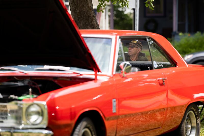 Russ Shuck is seen through the window of his ’67 Dodge Dart Friday, July 4, 2025, at the Petunia Fest car show in Dixon. Shaded by trees at John Dixon Park, hundreds filed through to check out the sweet rides.
