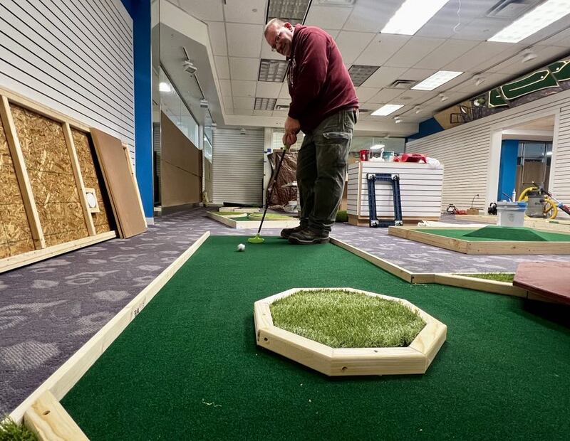 Owner Matthew Hicks lines up a shot at his new mini golf course, The 9th Hole Mini Golf & More inside Sterling's Northland Mall.