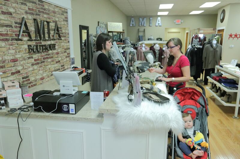 Amia Boutique employee Gianna Baracani of Spring Valley (left) rings up customer Amber Grenda of Ottawa, who was shopping with her son Atticus. Grenda said she buys most of her clothes at either the Amia Boutique location in La Salle and Spring Valley. She’s not the only one shopping in local stores. Illinois Valley sales tax reimbursements are eclipsing pre-recession heights.