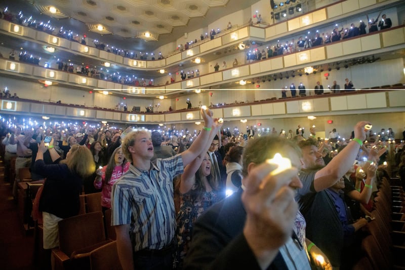 People hold candles and sing during a memorial and prayer vigil for Charlie Kirk at the John F. Kennedy Memorial Center for the Performing Arts, Sunday, Sept. 14, 2025, in Washington. (AP Photo/Rod Lamkey, Jr.)