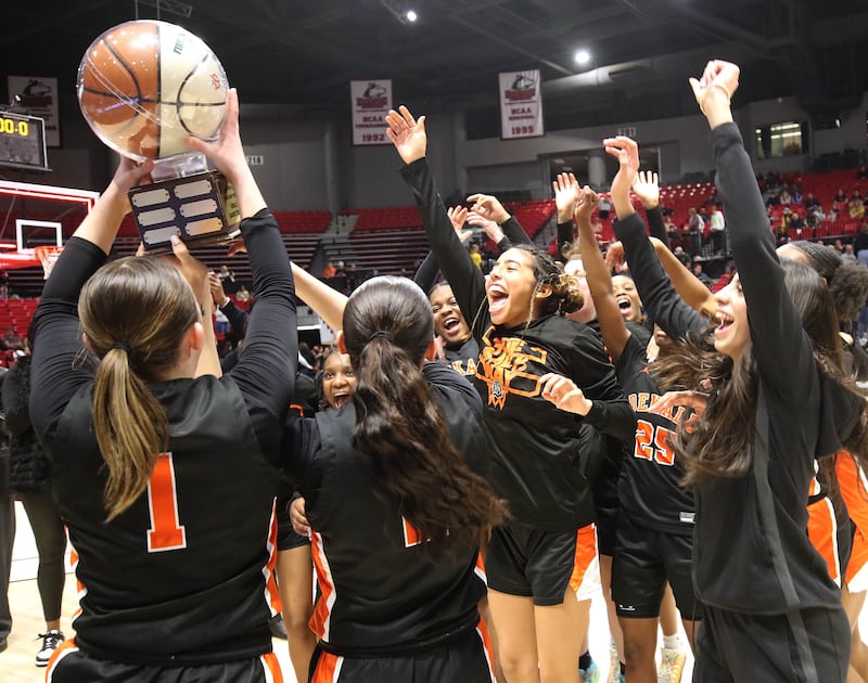 DeKalb players hoist the trophy after their win over Sycamore Friday, Jan. 31, 2025, in the FNBO Challenge in the Convocation Center at Northern Illinois University in DeKalb.