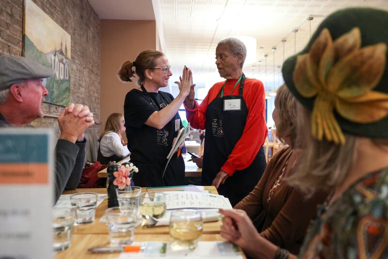 Guest server Nita Moffett, right, high fives helper Tiffany Heneghan during a Mistaken Orders program event, hosted by nonprofit Our Aging Services and MCA Senior Adult Day Center at Stefari West Avenue on Nov. 18, 2025. Heneghan is a board member with MCA Senior Adult Day Center.