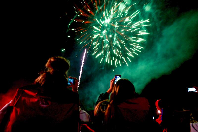 Spectators document the fireworks at the Aroma Park Boat Club's Cheeseburgers & Fireworks event in 2021.