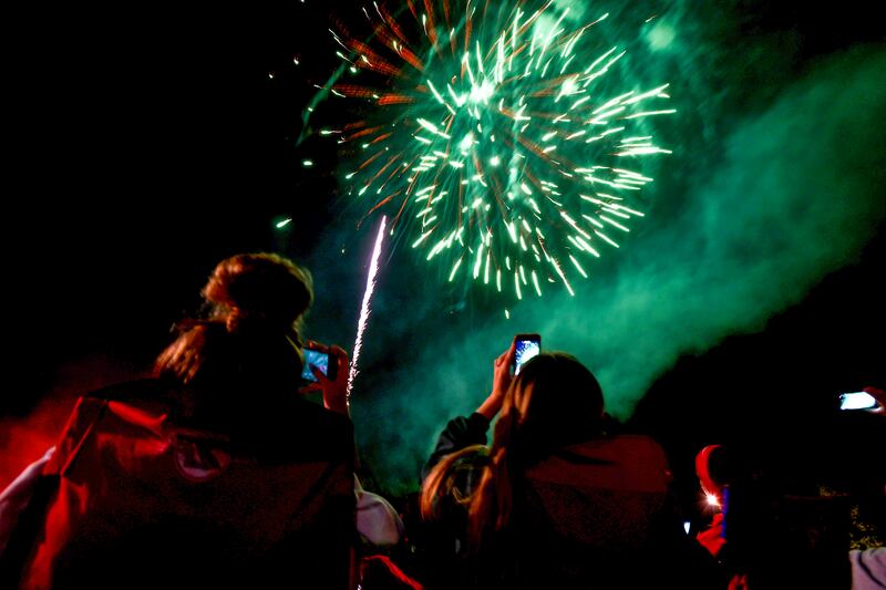 Spectators document the fireworks at the Aroma Park Boat Club's Cheeseburgers & Fireworks event in 2021.