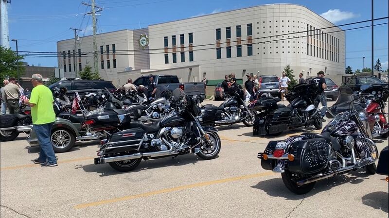 Sycaore 2-year-old Oliver Olinger (middle) held by dad Nathan Olinger, explores that dozens of motorcycles parked outside the Sycamore Public Library on Sunday, June 22, 2025. Olinger is celebrating nearly a year cancer free after completing treatment for leukemia. A motorcycle lover, Oliver got to visit the St. Charles Motorcycle Museum Sunday, escorted by police agencies and volunteer motorcyclists who wanted to help him celebrate remission.