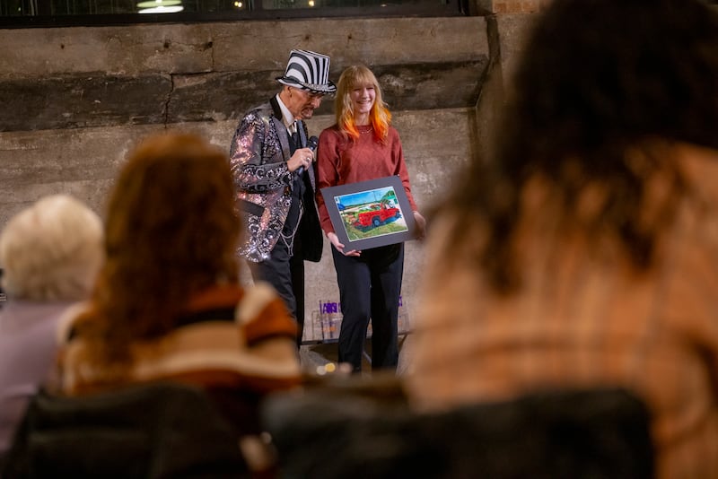 Gretchen Hauger of Ottawa Township High School presents her truck painting to the audience at the Mad Hatter Ball on January 17, 2024 at the Westclox Event Center.