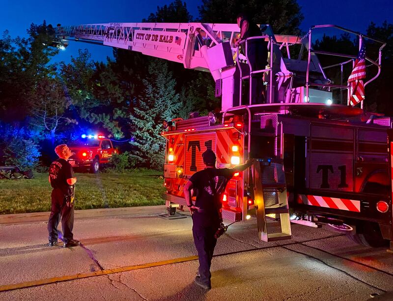 DeKalb firefighters are hoisted into the air on a ladder truck to help provide light to emergency divers undertaking a water rescue on Sunday, July 27, 2025, in the 600 block of Ridge Drive in DeKalb.