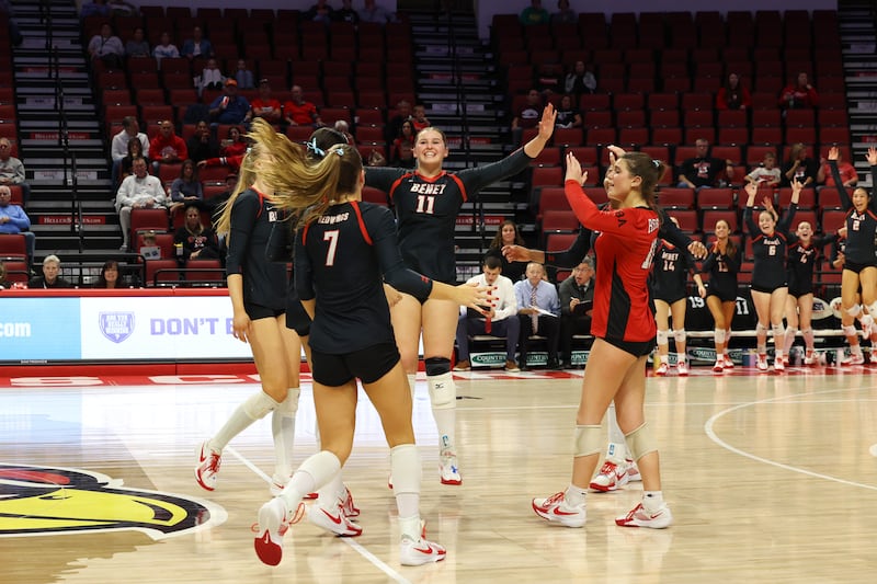 Benet Academy's Ellie Stiernagle, center, turns to celebrate with teammates as the Redwings secured a victory in two sets, 25-23, 25-16, over Lockport in the IHSA Class 4A State semifinals on Friday, Nov. 14, 2025.