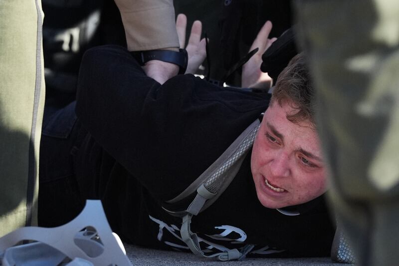 Illinois State police detain a protester outside an ICE processing facility in the Chicago suburb of Broadview, Ill., Friday, Nov. 14, 2025. (AP Photo/Nam Y. Huh)