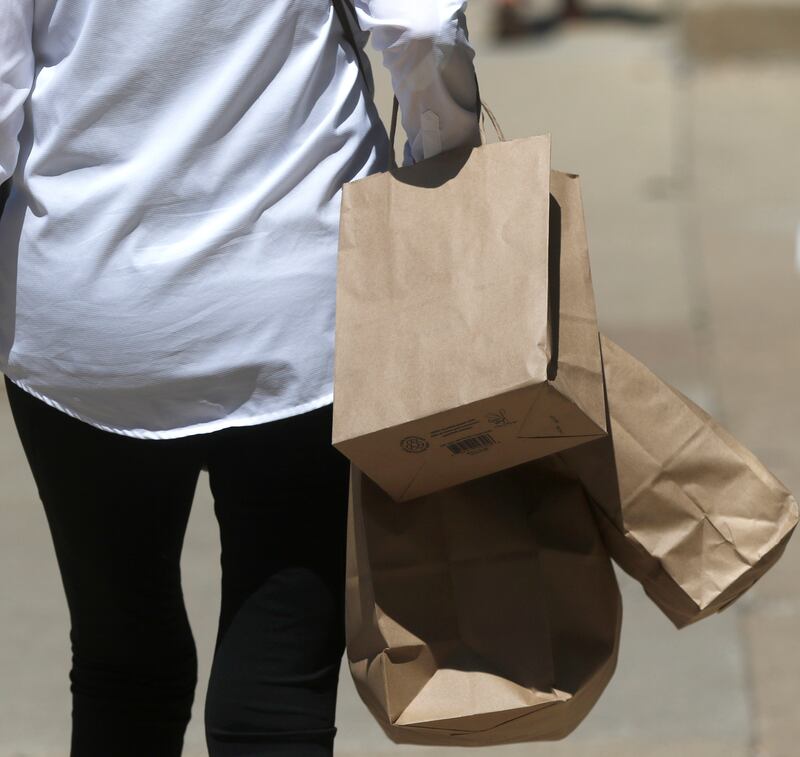 A shopper walks around Woodstock Square in 2023. Shopping could be more expensive in town as the city considers an increase in its sales tax.