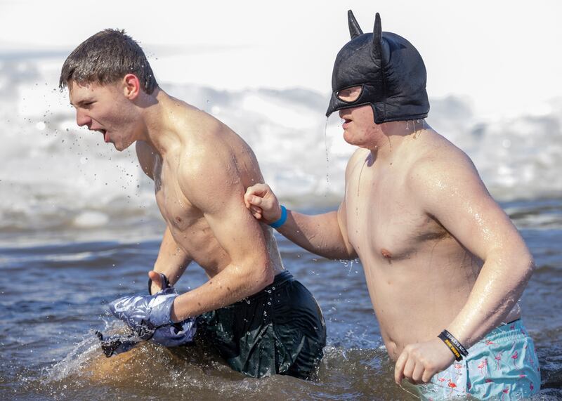 Two plungers flee the icy waters during the Polar Plunge for Special Olympics on February 22, 2025 at Lake Mendota.