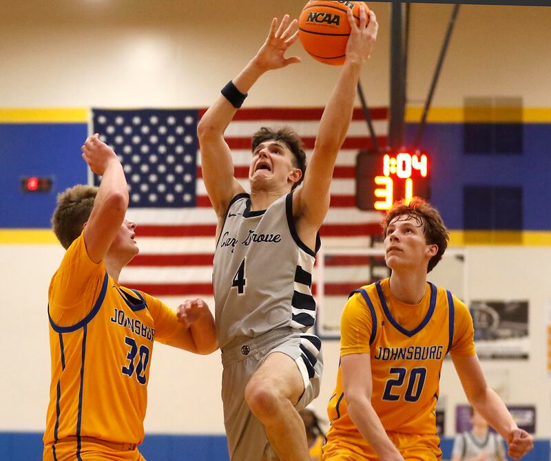 Cary-Grove's Dylan Dumele drives to the basket between Johnsburg's Jayce Schmitt (left) and Josh Kaunas (right) during a Johnsburg Thanksgiving Tournament boys basketball game on Monday, Nov. 24, 2025, at Johnsburg High School.