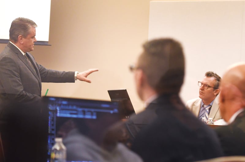 Defense attorney Christopher DeRango (left) cross examines Illinois State Police Special Agent Nate Macklin (right) on Friday, Jan. 16, 2026 about text messages and other data extracted from the cell phone of Duane C. Meyer (center) in 2016.