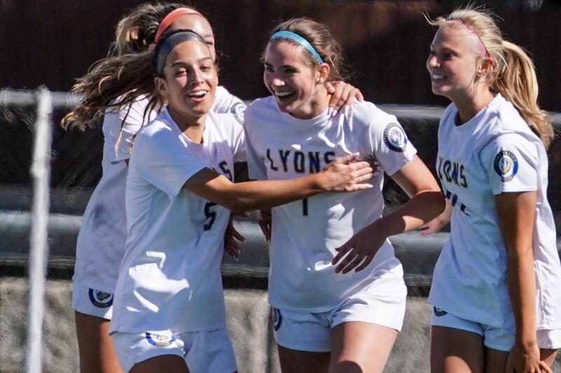 Lyons’ Jillian Herchenroether (5) hugs Caroline Mortonson (7) after Mortonson scored her second goal of the game against York during a Class 3A Hinsdale Central Sectional girls soccer championship match at Hinsdale Central High School on Saturday, May 25, 2024.