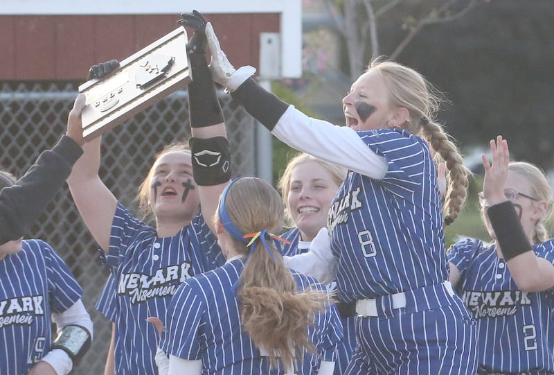 Members of the Newark softball team gather to accept the Class 1A regional plaque after defeating Earlville in the final Thursday, May 22, 2025, at Indian Creek High School in Shabbona.