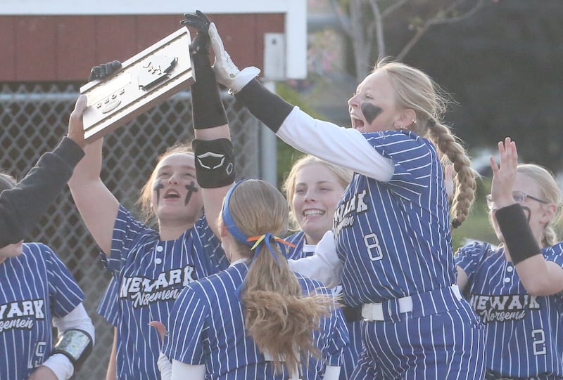 Members of the Newark softball team gather to accept the Class 1A regional plaque after defeating Earlville in the final Thursday, May 22, 2025, at Indian Creek High School in Shabbona.