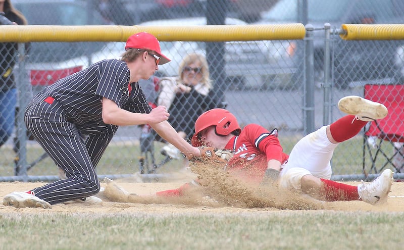 Hall third baseman Hunter Edgcomb tags out Streator's Colin Byers trying to advance to third base on a ball in the dirt Tuesday, March 18, 2025, at Foley Field in Spring Valley.