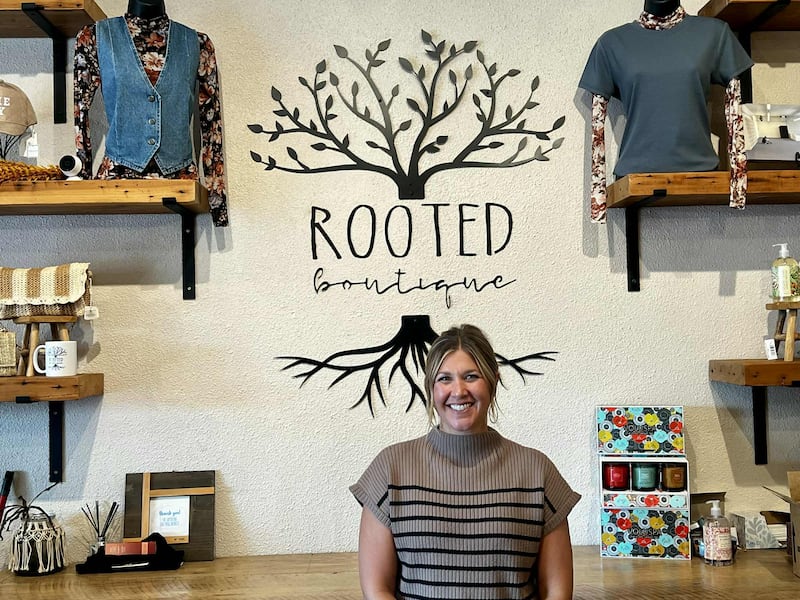 Jackie Wilkin, owner of Rooted Boutique in downtown Fulton, stands behind the counter of her shop, which marked its fifth anniversary this month.