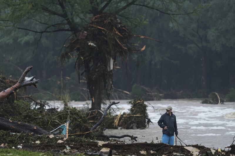 A man surveys debris along the Guadalupe River after a flash flood struck the area, Friday, July 4, 2025, in Kerrville, Texas. (AP Photo/Eric Gay)