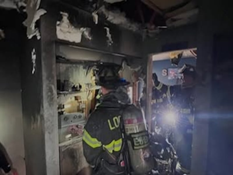 Firefighters from the Lockport Township Fire Protection District inspect damage to a Crest Hill home after extinguishing a fire on Tuesday, March 18, 2025.