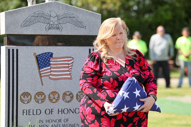 Karen Smietanski, assistant superintendent at the Veterans Assistance Commission of Kankakee County, holds a folded flag dedicated to the late John Kirnbauer, a veteran whose ashes went unclaimed for five years, during a ceremony in his honor on Monday, May 26, 2025, at Kankakee Memorial Gardens.