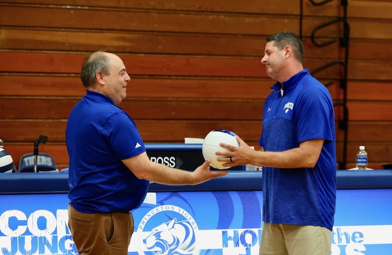 Princeton' Athletic Director Jeff Ohlson presents a commemorative ball to coach Andy Puck in recognition of his milestone in become the winningest coach in program history Tuesday night at Prouty Gym.