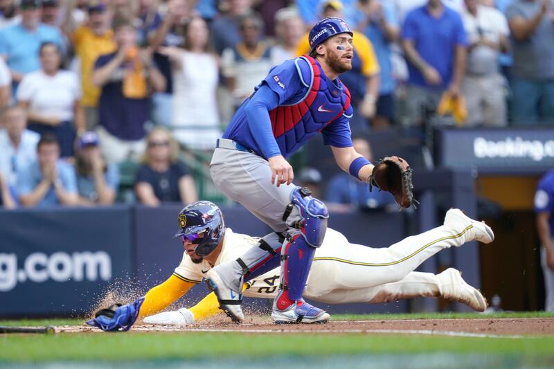 Milwaukee Brewers' William Contreras (24) scores as Chicago Cubs catcher William Contreras (15) waits for the throw during the first inning in Game 1 of baseball's National League Division Series, Saturday, Oct. 4, 2025, in Milwaukee. (AP Photo/Kayla Wolf)