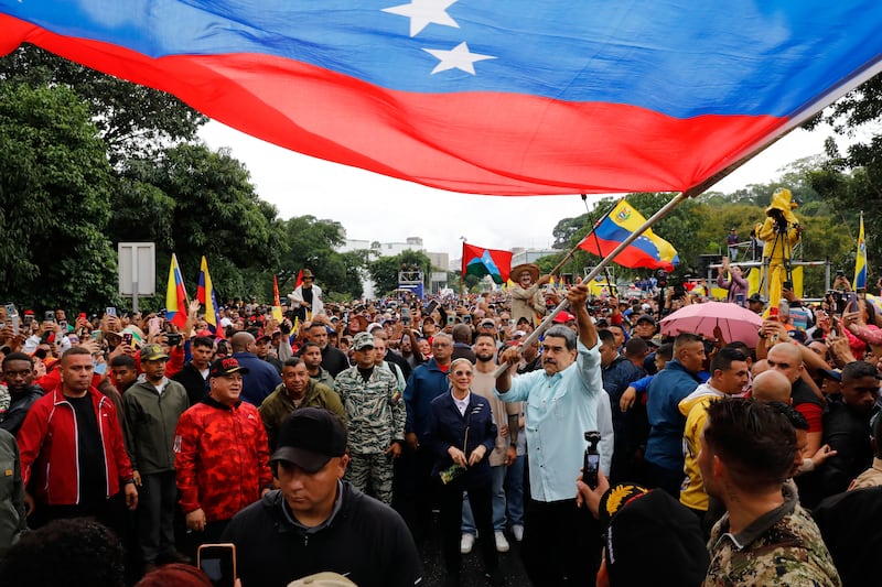 President Nicolas Maduro waves a flag during a rally marking the anniversary of the Battle of Santa Ines, which took place during Venezuela's 19th-century Federal War, in Caracas, Venezuela, Wednesday, Dec. 10, 2025. (AP Photo/Cristian Hernandez)