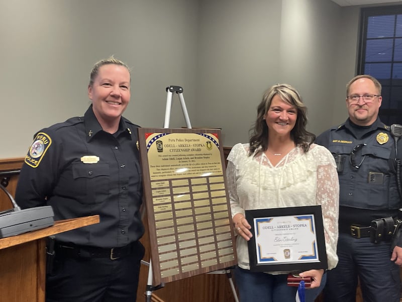 Edin Sterling (second from left) was awarded for heroism Monday, March 9, 2026, at the Peru City Council by Chief Sarah Raymond (left) and Sgt. Scott DeGroot.